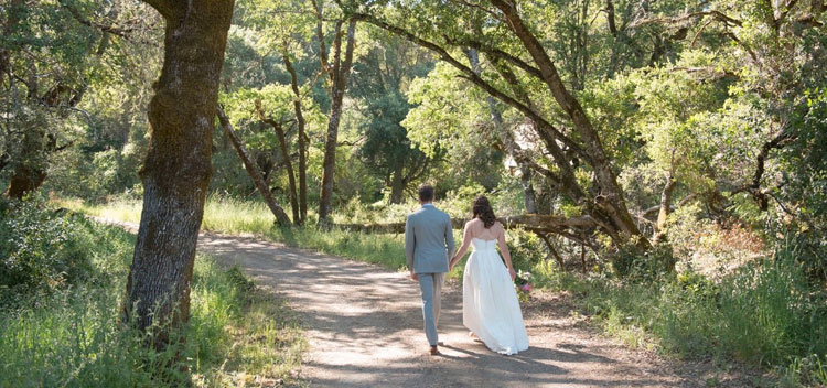 a couple walk down the wooded road at The Toll House at Bell Valley Retreat in Anderson Valley, Mendocino County, California