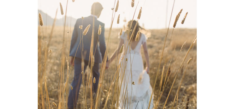 couple walks through a meadow during their wedding at The Toll House at Bell Valley Retreat in Anderson Valley, Mendocino County, California