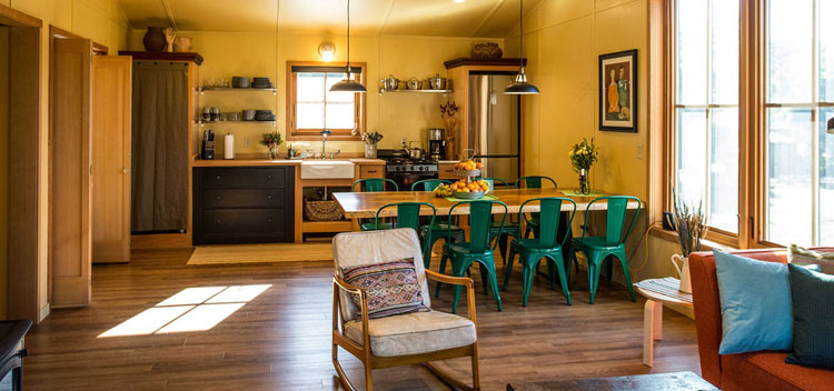 barn living space upstairs with dining table and open plan kitchen